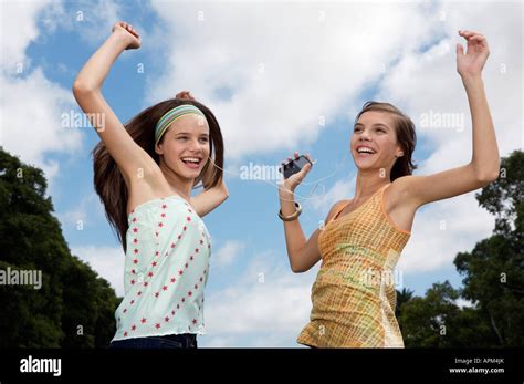 Two Teenage Girls Listening Music From Mp3 Player Stock Photo Alamy