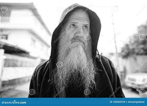 Face Of Mature Bald Man With Long Gray Beard Thinking In The Streets