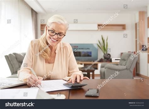 Portrait Smiling Mature Woman Calculating Expenses Stock Photo