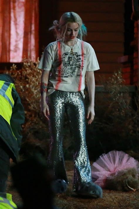 A Woman With Blue Hair Wearing Sequin Pants And A White T Shirt