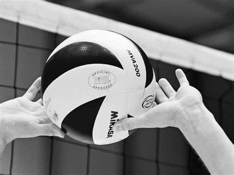 Black And White Photograph Of A Volleyball Being Held Up By A Person S Hand