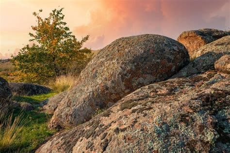 Un pequeño montón de piedras antiguas en un gran campo verde amarillo