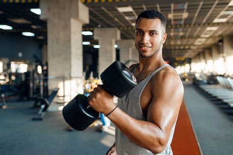 Hombre Musculoso Posa Con Pesas Pesadas En El Entrenamiento En El