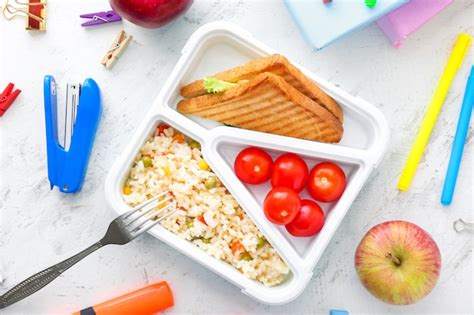 Premium Photo | School lunch box with tasty food and stationery on table