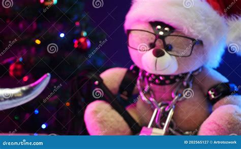 A Toy Teddy Bear Wearing A Santa Claus Hat On Christmas Day Is Chained