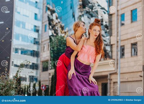 Two Well Dressed Women Pose Confidently In A Modern Urban City With