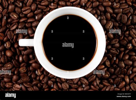 Cup Filled With Coffee On Coffee Beans Background Top View Stock Photo