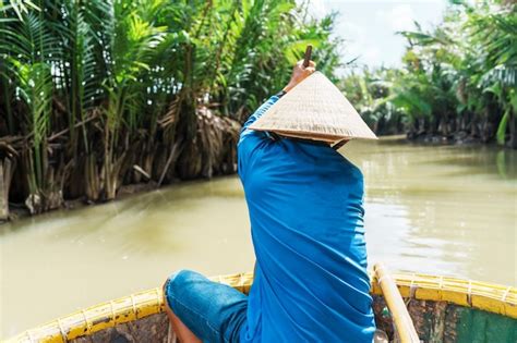 Premium Photo Man Rowing A Basket Boat Along The Coconut River Forest