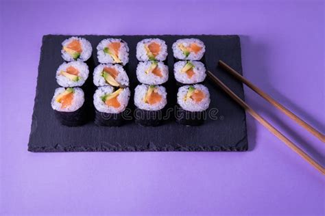 Maki Sushi Met Zalm En Avocado Op Een Leisteenplaat Met Stokjes Op