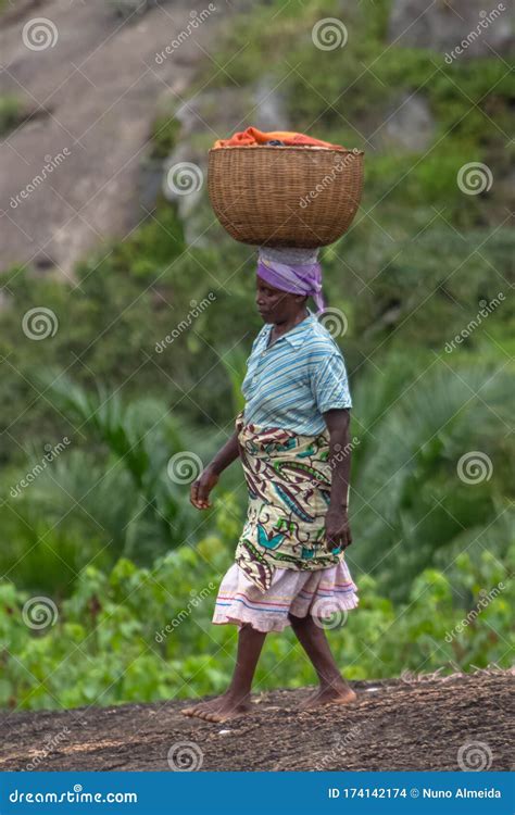 View Of Typical African Elderly Woman Carrying Wicker Basket On Her