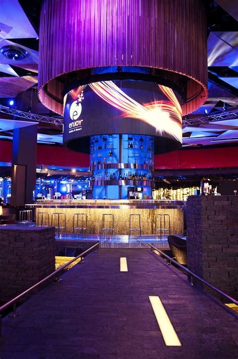 The Inside Of A Bar With Purple Lighting And Large Circular Chandelier