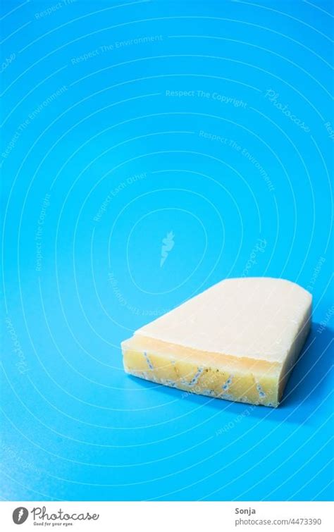 A Piece Of Moldy Parmesan Cheese On A Blue Background A Royalty Free