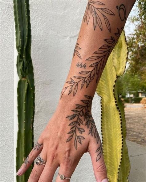 A Woman S Hand With Tattoos On It And A Cactus In The Back Ground