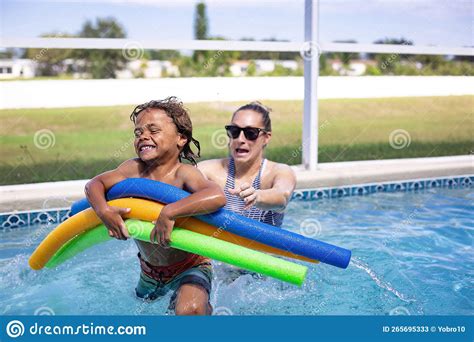 Smiling African American Little Boy Playing In The Swimming Pool With His Mother Having Fun