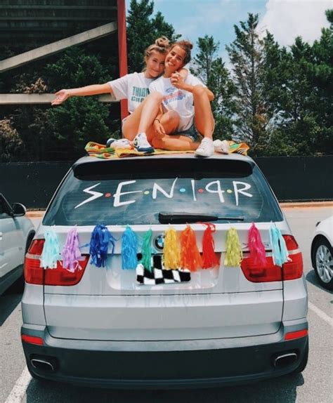 Two People Sitting On The Back Of A Car