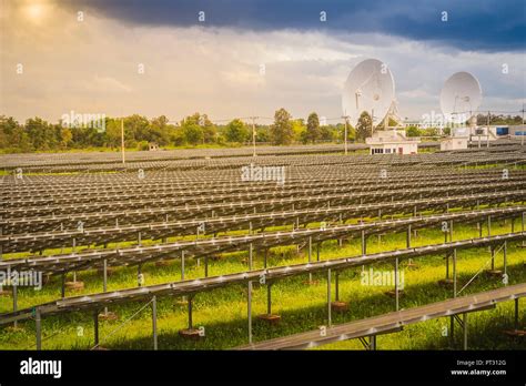 Large Scale Solar Farm With The Satellite Dishes Under Dramatic Blue