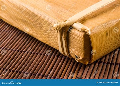 Chinese Pressed PU Erh Tea In Bamboo Leaf Packaging On A Bamboo Mat