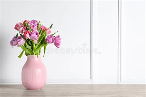 Beautiful Bouquet Of Colorful Tulip Flowers On Floor Near White Wall