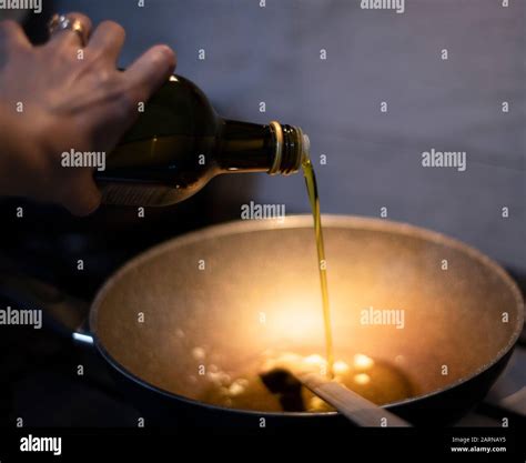 Pouring Extra Virgin Olive Oil Into A Hot Pan On A Gas Cooker In A