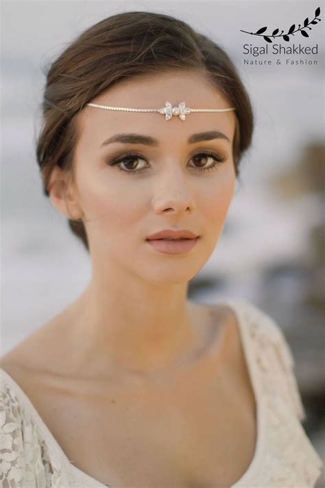 A Woman Wearing A Head Piece With Flowers On Its Forehead And Eyeshade