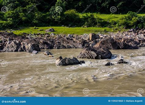 Stream Of The River Ganges With Rocks On The Shore And A Green Forest