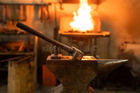 Hammer On Anvil In Forge On Furnace With Fire Background In Smithy