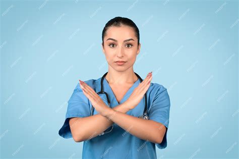 Premium Photo Serious European Woman Nurse In Blue Uniform Crossing