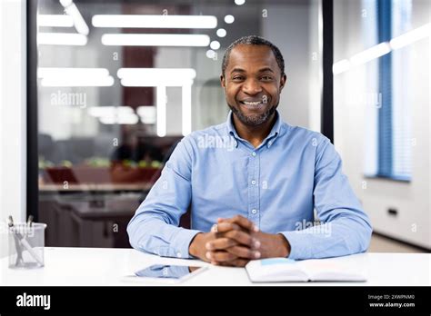 Mature African American Businessman Sitting At Modern Office Desk