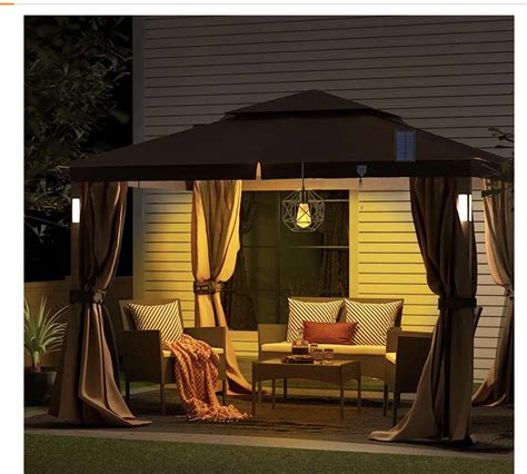 A Gazebo Lit Up At Night In Front Of A House With Curtains On It