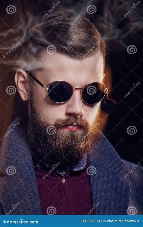 Bearded Fashionable Man In Sunglasses Smoking Cigar Stock Photo