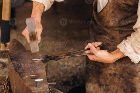 A Blacksmith Manually Forges Red Hot Metal On An Anvil With A Hammer Stock Photo At