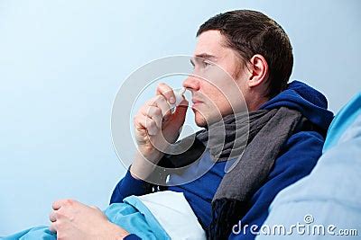 Side Photo Of Sick Brunet Male Using Nasal Spray While Lying In Bed