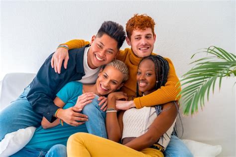 Parejas lgtb de chicos y chicas gay lesbianas en un retrato en un sofá en una fiesta en casa