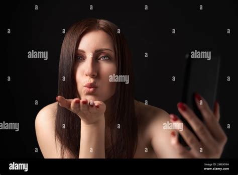 Woman Blowing Lips Sending Air Kisses Over Palm And Taking Selfie To