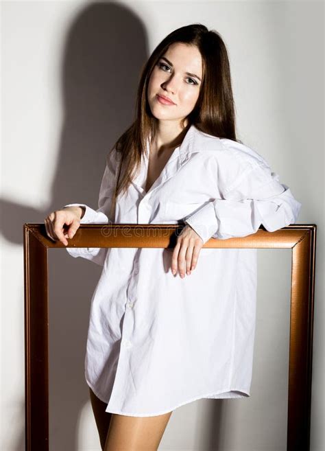 Naked Girl In A Man S White Shirt Holding Wooden Frame Stock Image