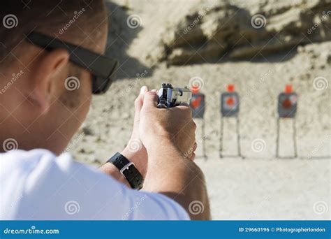 Homem Que Aponta a Arma Da Mão Na Escala De Acendimento Foto de Stock