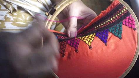 A Person Is Stitching Something On An Orange Pillow