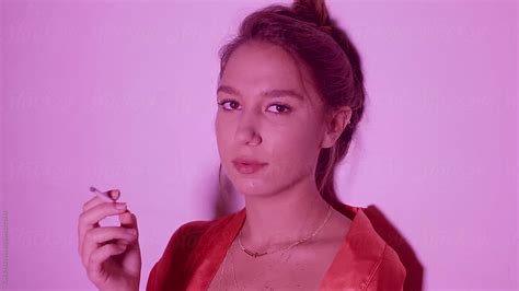 Sensual Woman In Pink Smoking Cigarette By Stocksy Contributor