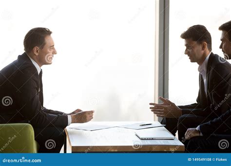 Concentrated Businessmen Negotiate At Meeting Discussing Cooperation