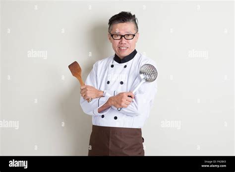 Portrait Of Confident S Mature Asian Male Chef In Uniform Hands