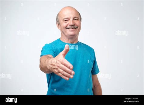 You Are Welcome Concept Cheerful Mature Man In Blue T Shirt Gesturing