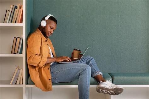 Hombre De Tiro Completo Estudiando Con Auriculares Foto Premium