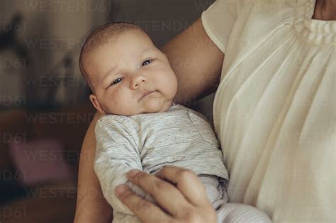 Newborn Baby Being Held In Mothers Arms Stock Photo