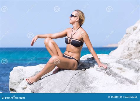 Tanned Blond Woman In Bikini And Sunglasses At The Sea Stock Image