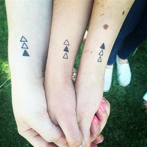 Two People With Matching Tattoos On Their Arms