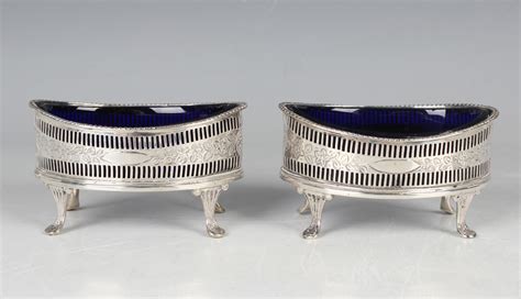 A Pair Of Late Victorian Silver Elliptical Shaped Salts Each With An Engraved Band Of Flowers And L