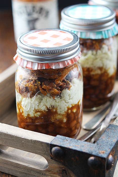 Two Jars Filled With Food Sitting On Top Of A Wooden Table Next To A