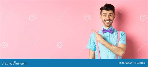 Portrait Of Handsome Happy Man Showing Logo Pointing Left And Smiling