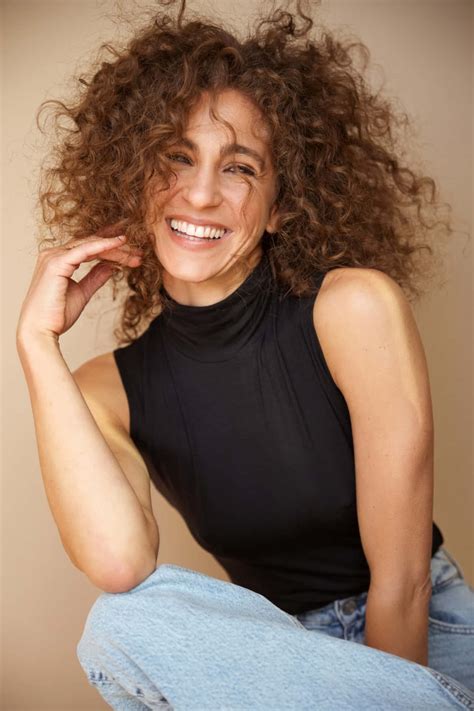 Download Curly Haired Woman Smiling Casually Wallpaper