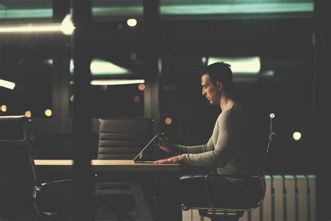 man working on laptop in dark office 12441426 Stock Photo at Vecteezy